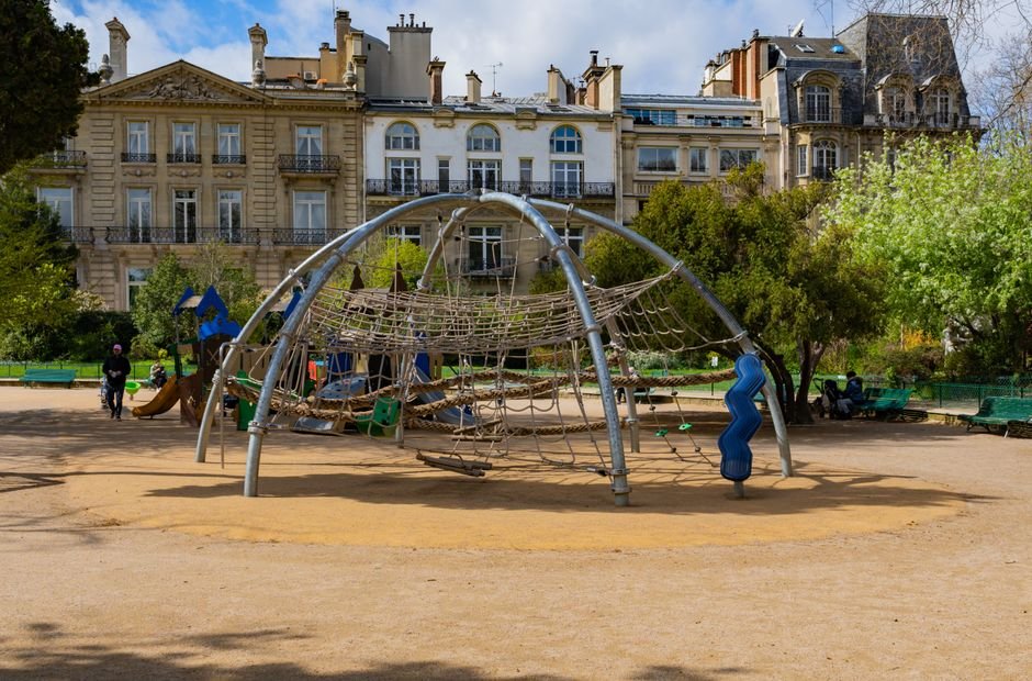 Šiuolaikinė žaidimų aikštelė su laipiojimo konstrukcijomis saulėtame parke, puikus pavyzdys jūsų vaikams