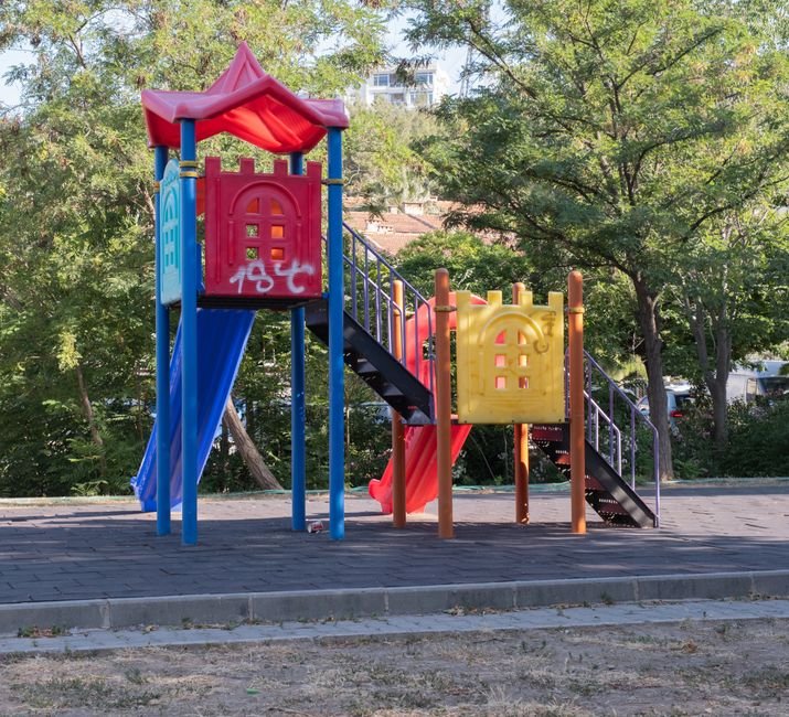 Ryškūs vaikų žaidimų aikštelės elementai saulėtame parke – ateities tendencijos